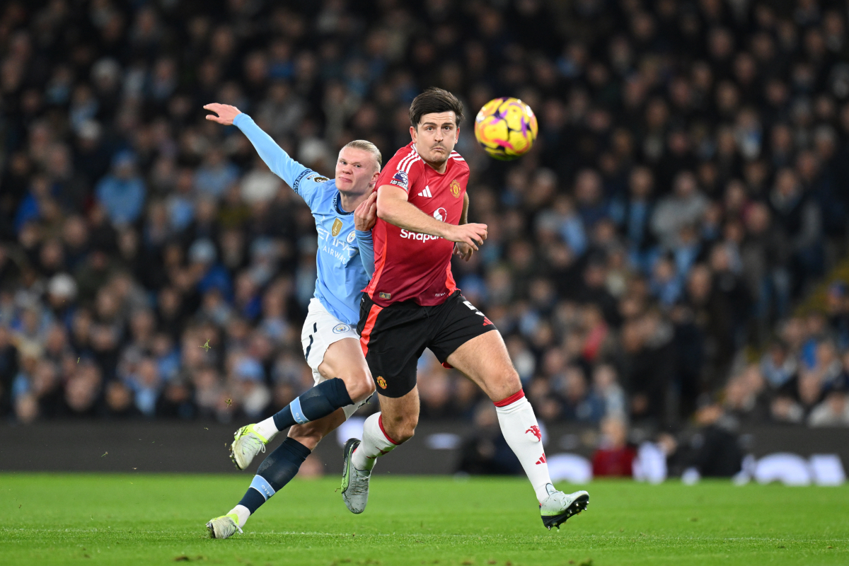 Harry Maguire vies with Erling Haaland.