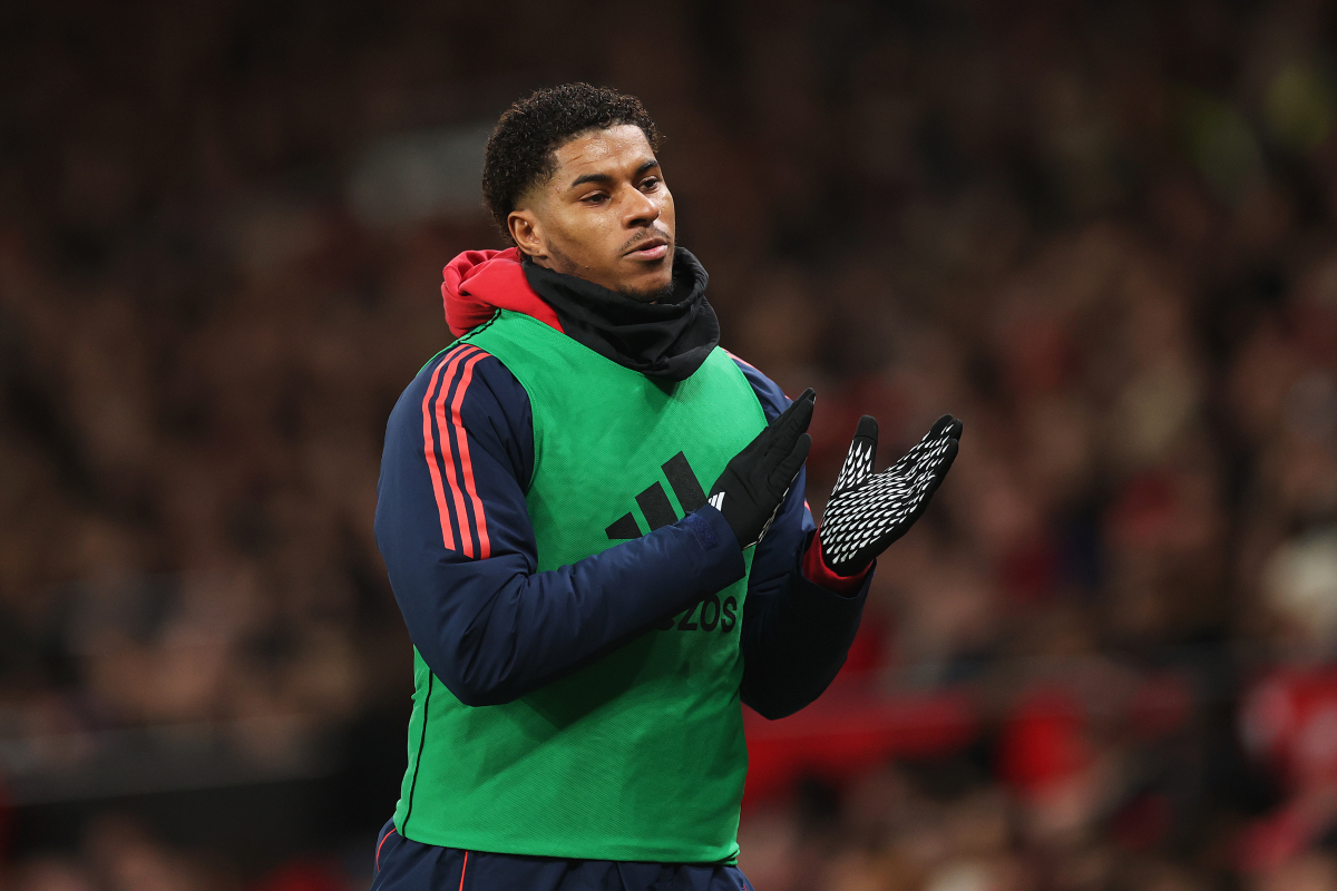 Marcus Rashford applauds the fans at Old Trafford while he warms up.