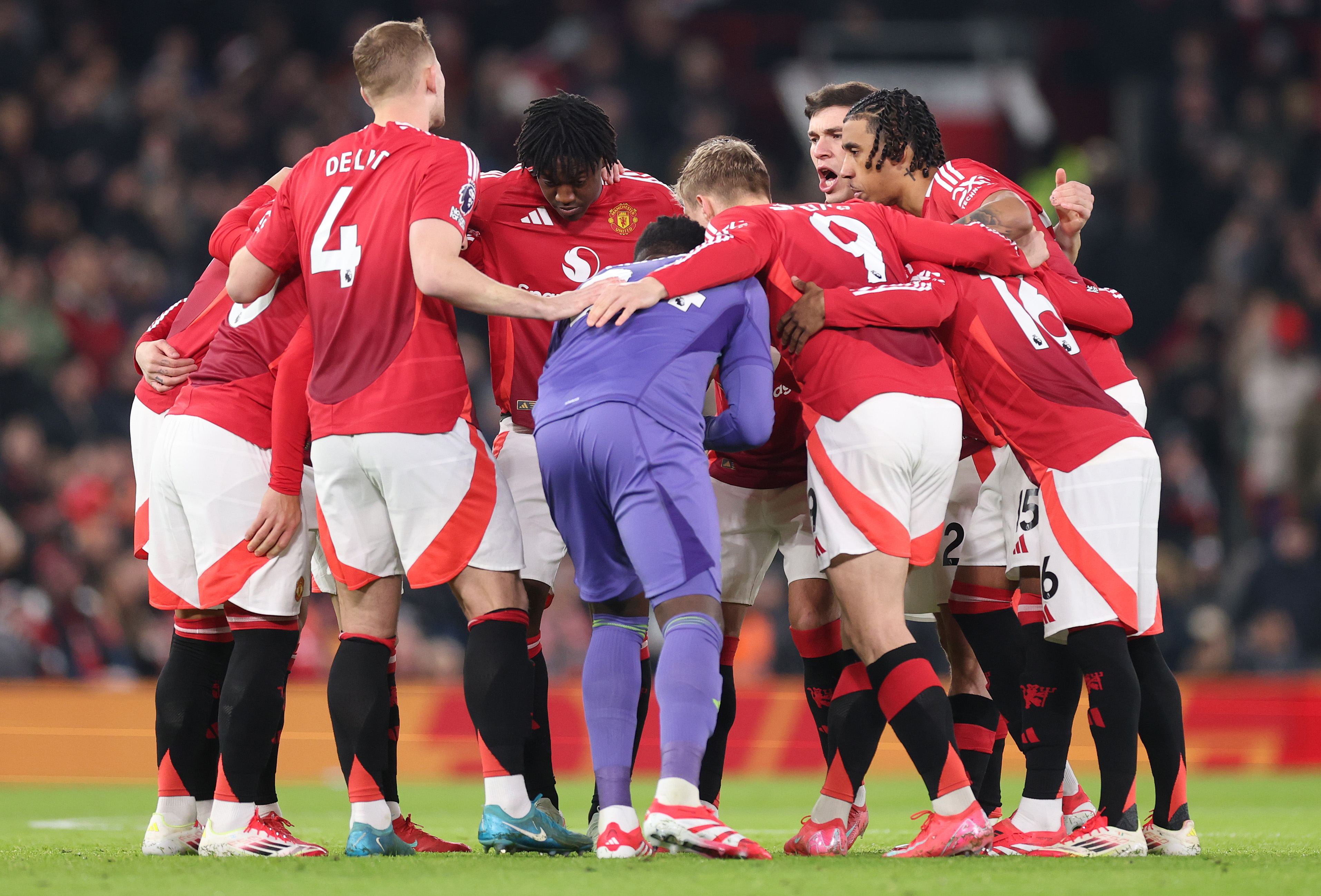 Manchester United players huddle ahead of kick-off at Old Trafford.