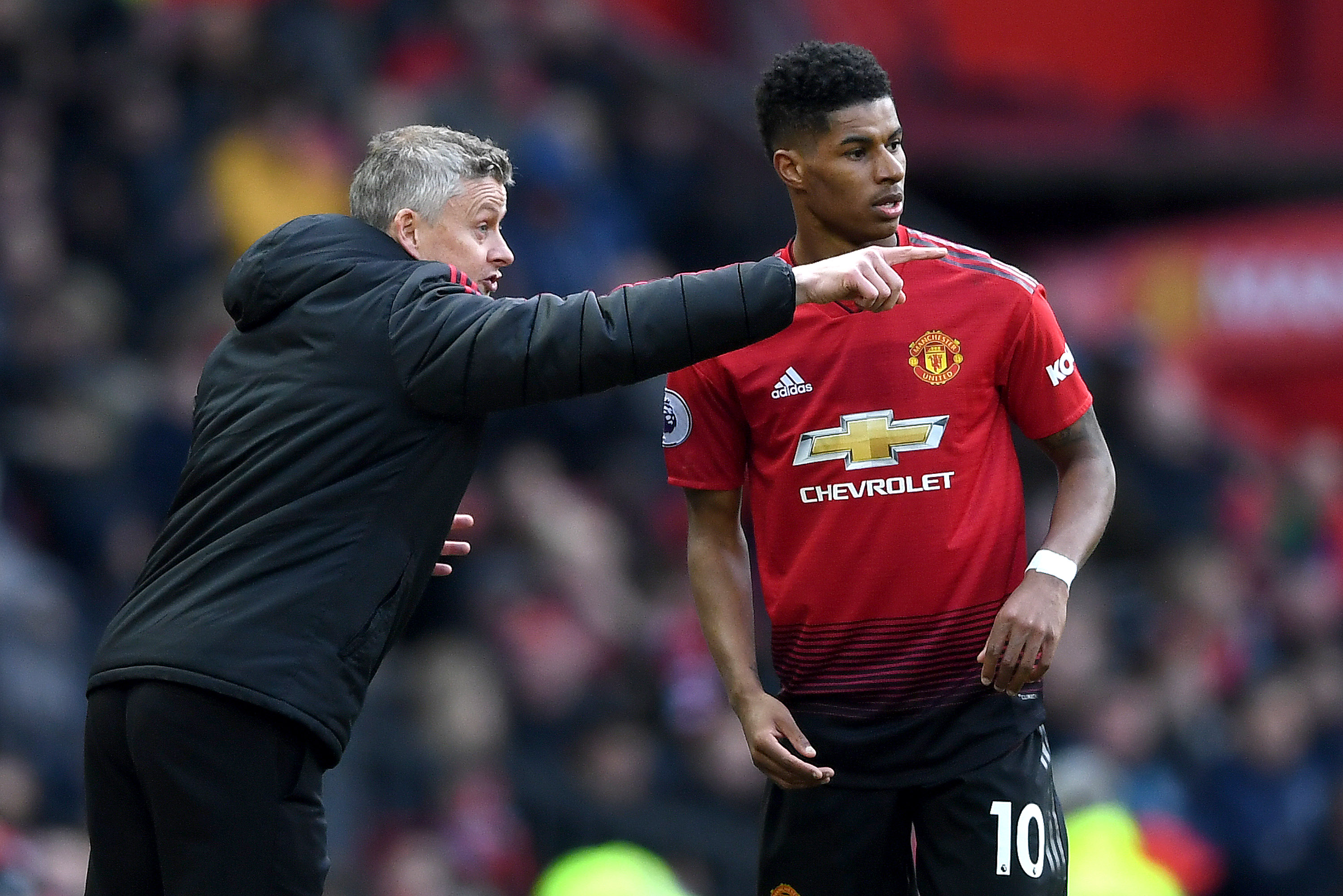 Marcus Rashford takes instructions from Ole Gunnar Solskjaer at Old Trafford.