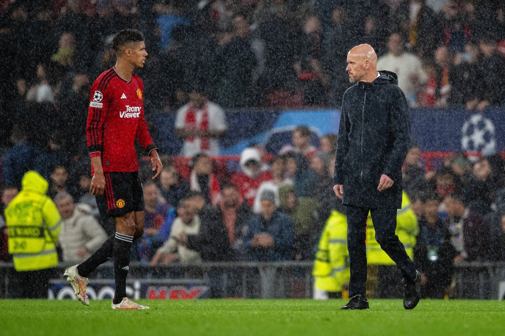 Erik ten Hag and Raphael Varane look on during a Champions League match at Old Trafford.