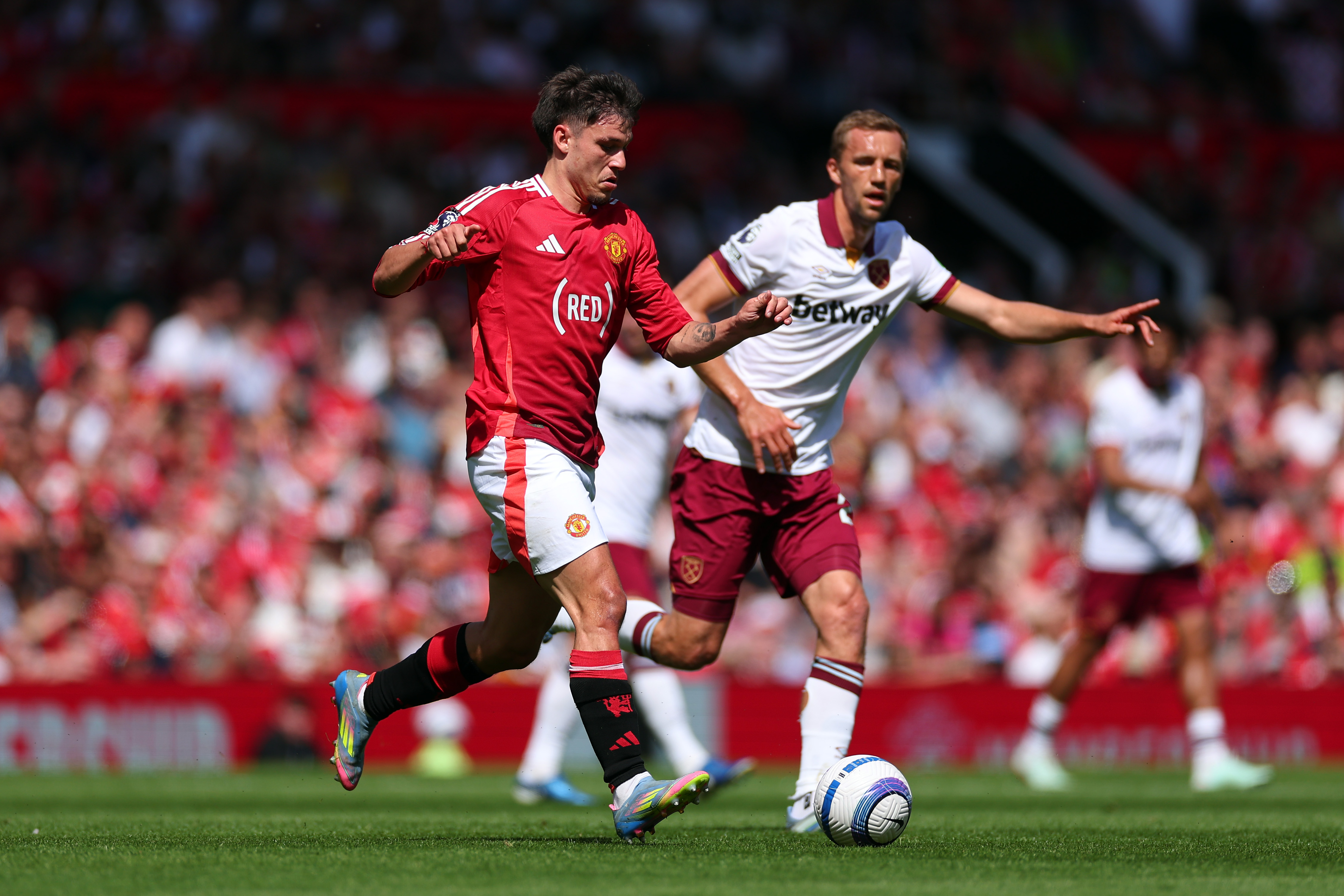 Manuel Ugarte carries the ball while under pressure from Thomas Soucek.