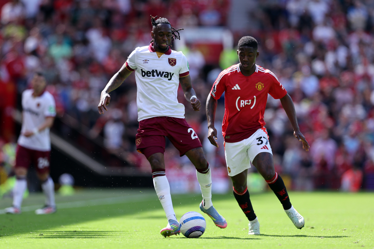 Aaron Wan-Bissaka carries the ball whilst under pressure from Kobbie Mainoo at Old Trafford.