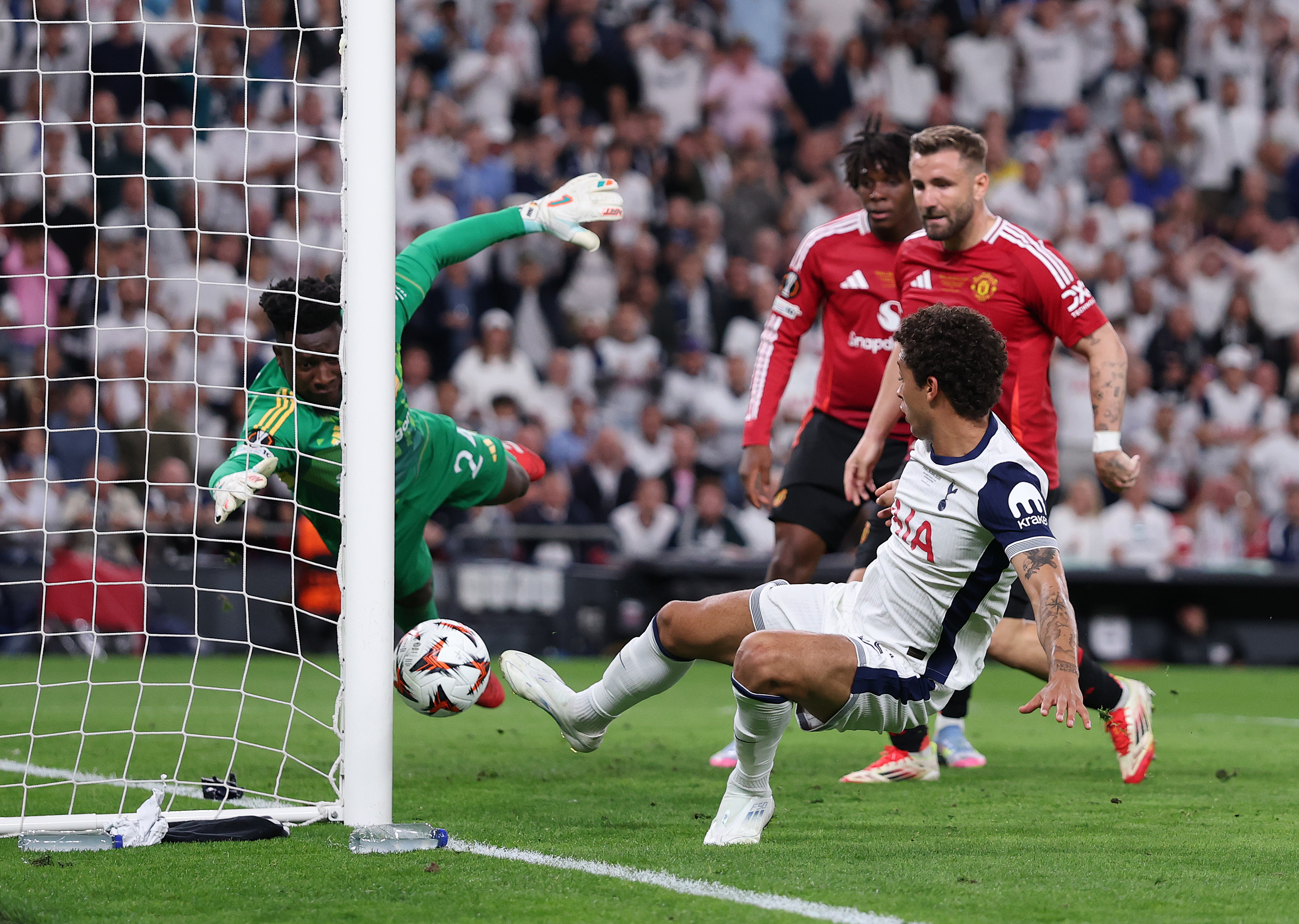 Luke Shaw and Patrick Dorgu watch on as Brennan Johnson scores past Andre Onana in the Europa League final.