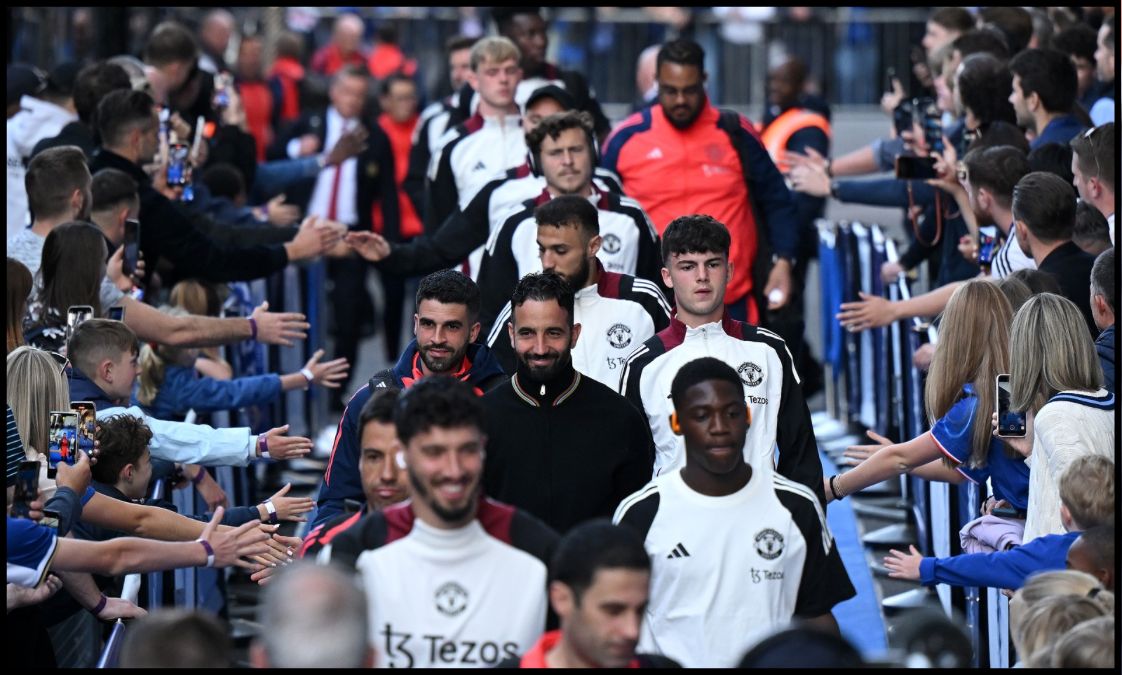 Ruben Amorim smiles at fans as he and his Man United players arrive at Stamford Bridge.