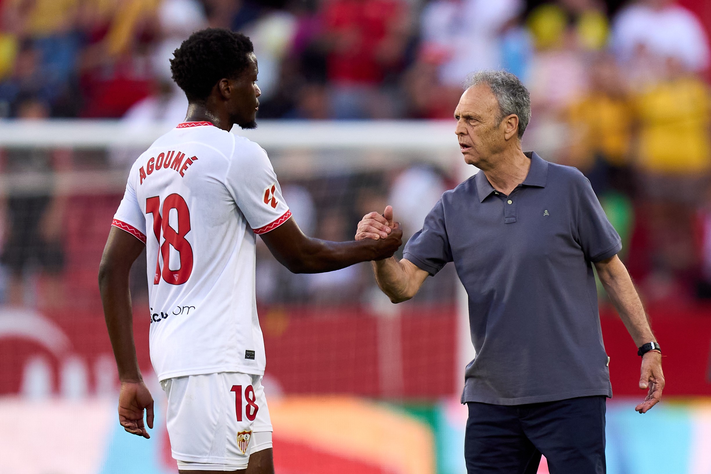 Joaquin Caparros, Head Coach of Sevilla FC, shakes hands with Lucien Agoume