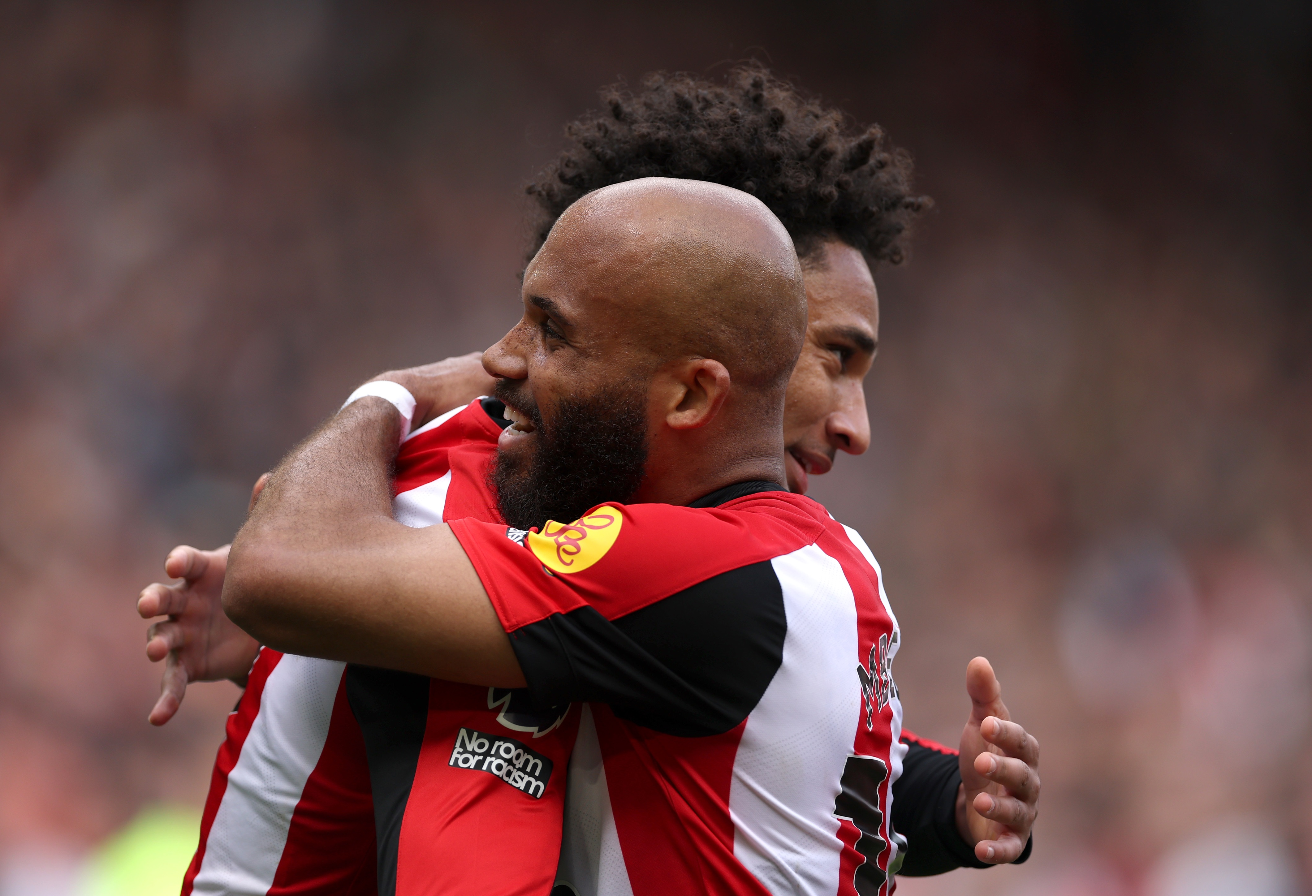 Bryan Mbeumo hugs Kevin Schade after Brentford goal.