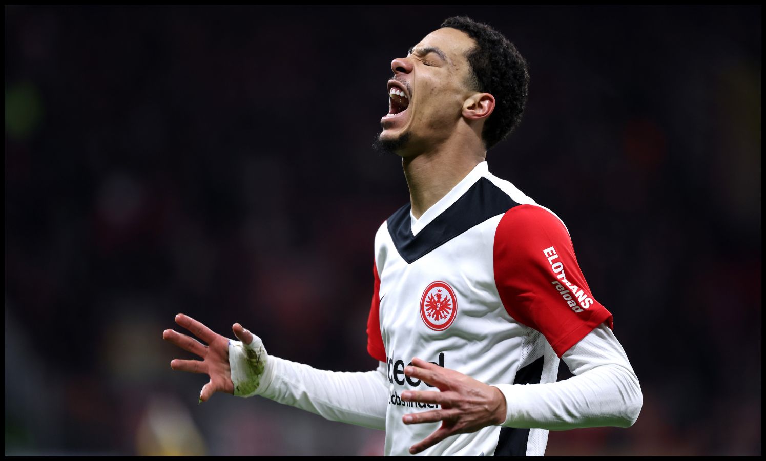 Hugo Ekitike screams in frustration with his hands raised.