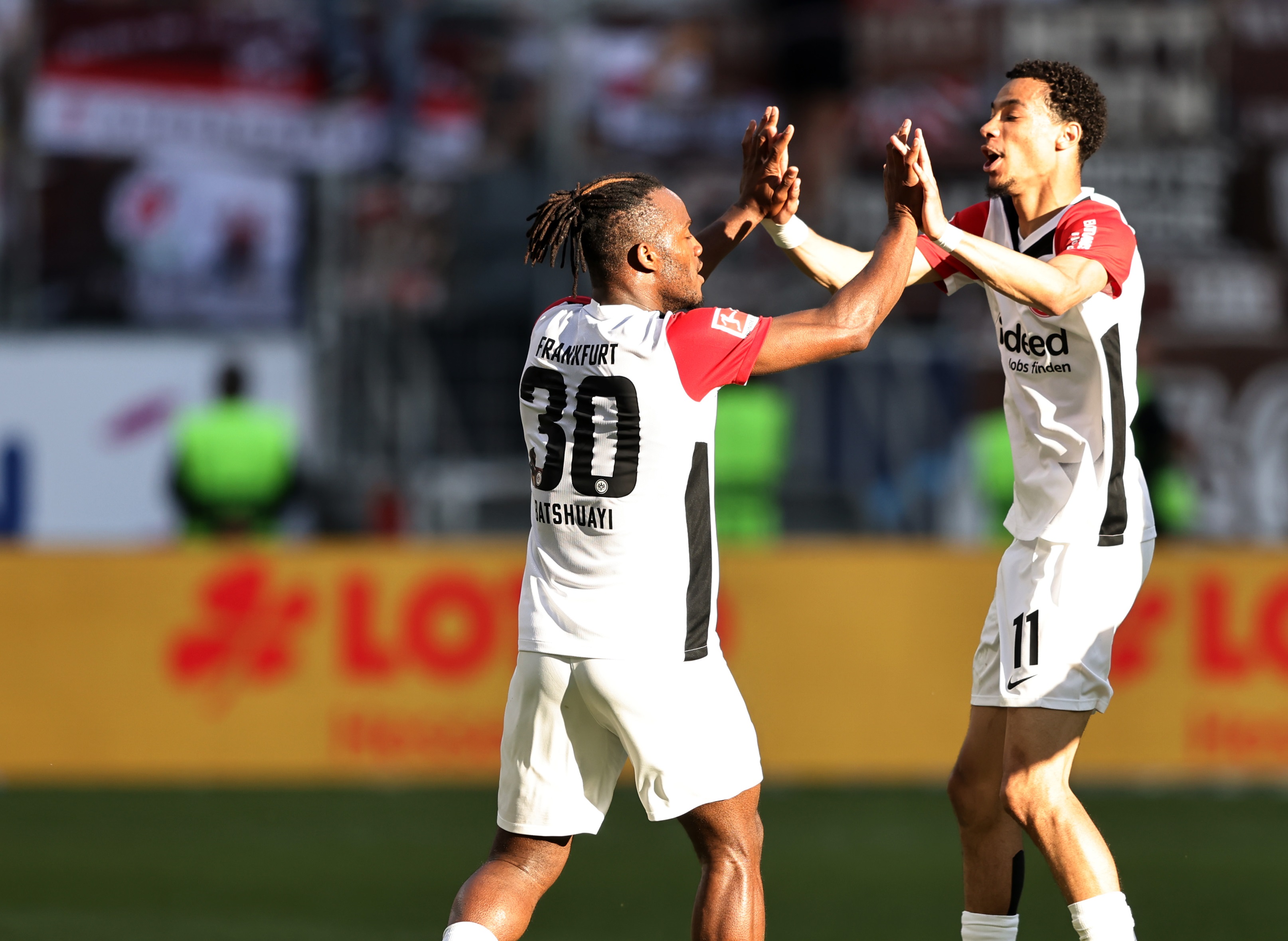Hugo Ekitike high fives Eintracht Frankfurt teammate Michy Batshuayi.