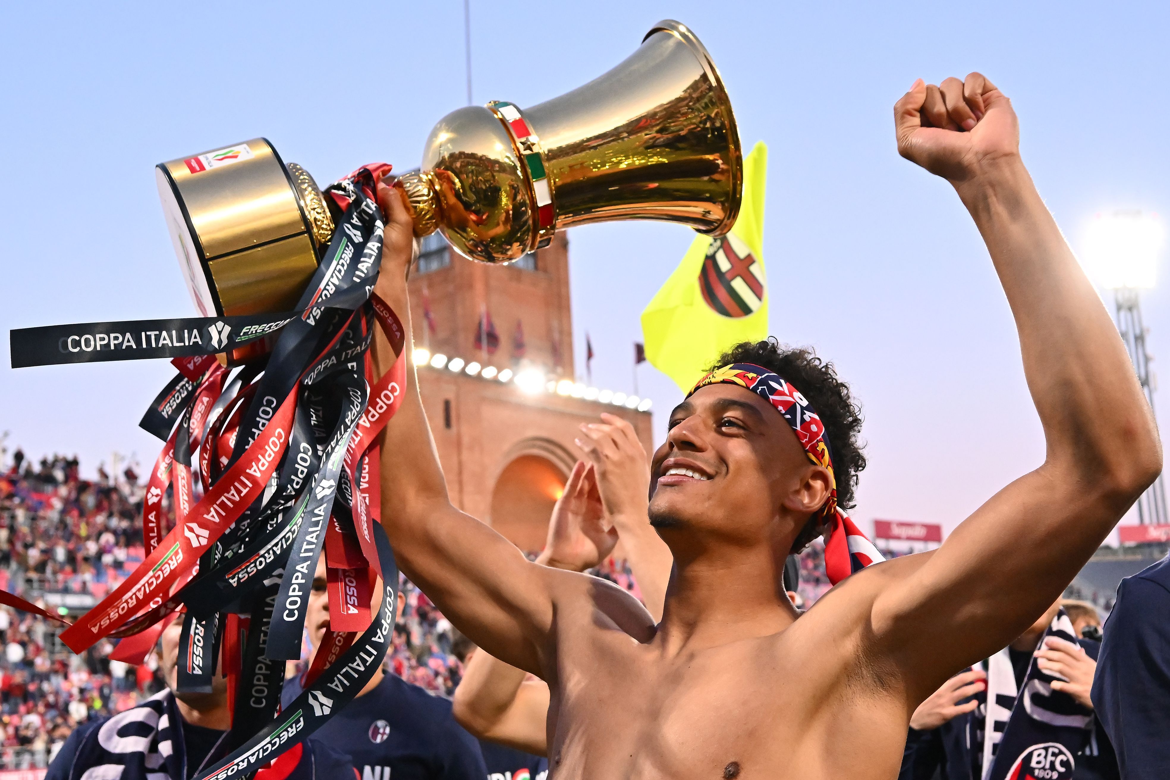 Dan Ndoye celebrates with the Coppa Italia trophy.