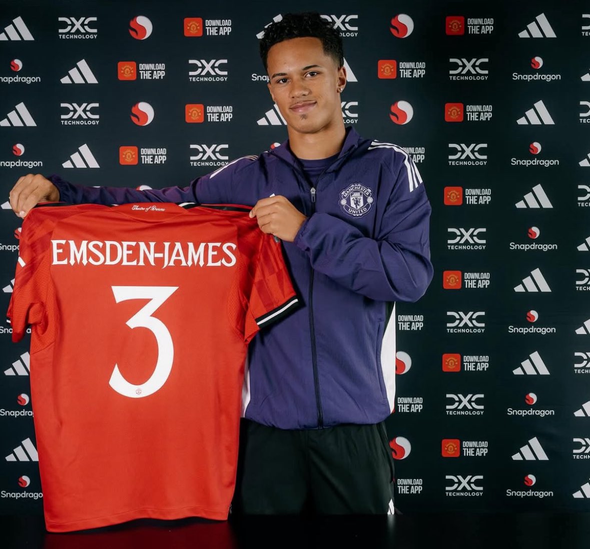 Harley Emsden-James holds up his Man United shirt after signing for the club.