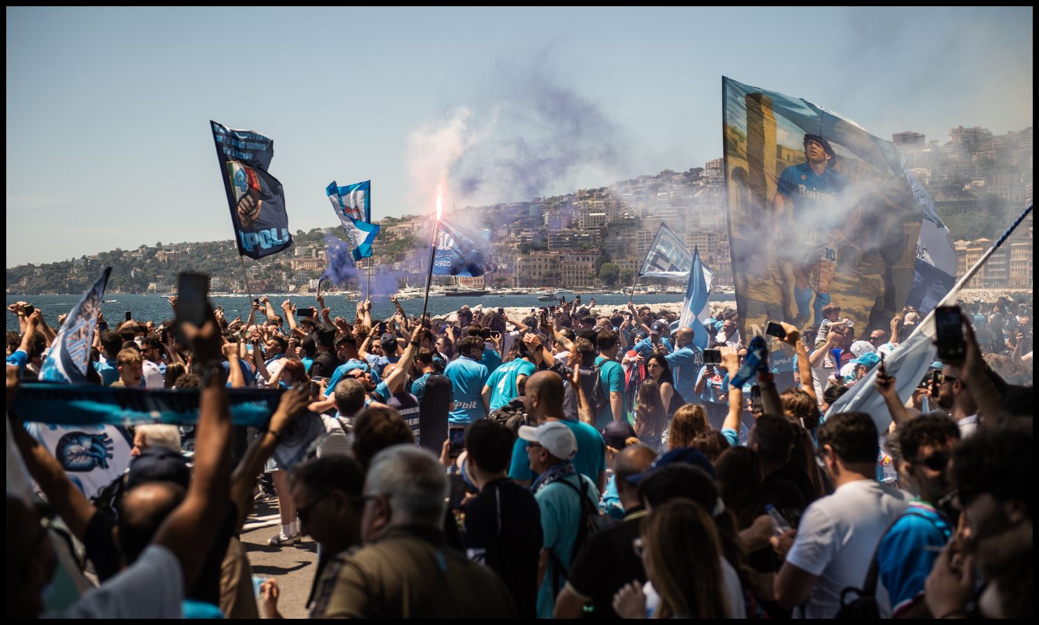 Napoli fans await the players on their bus tour of the city after winning the league.