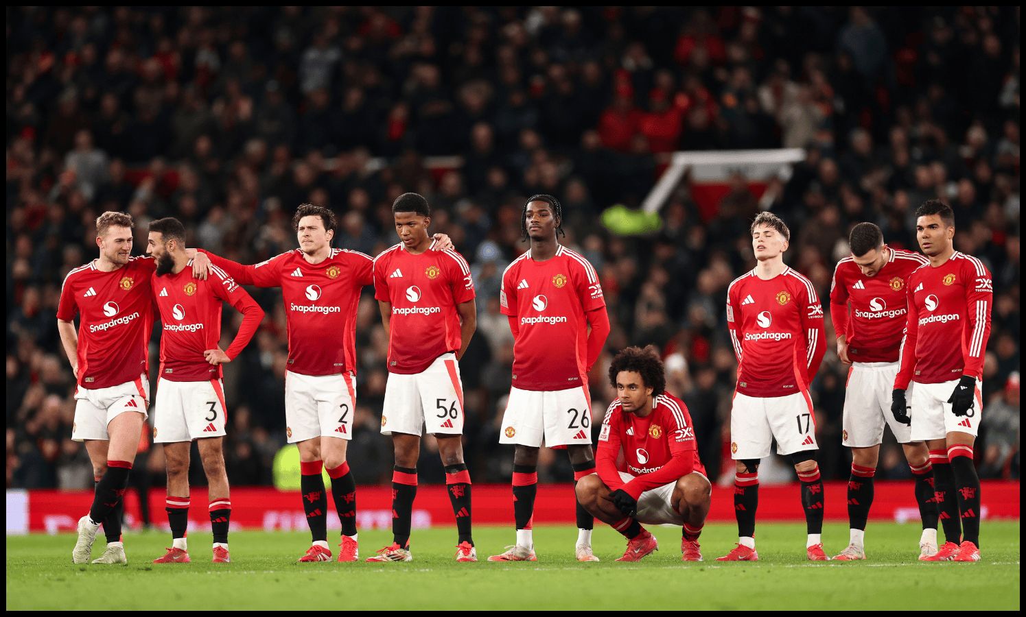 Man United players watch on during a penalty shootout.