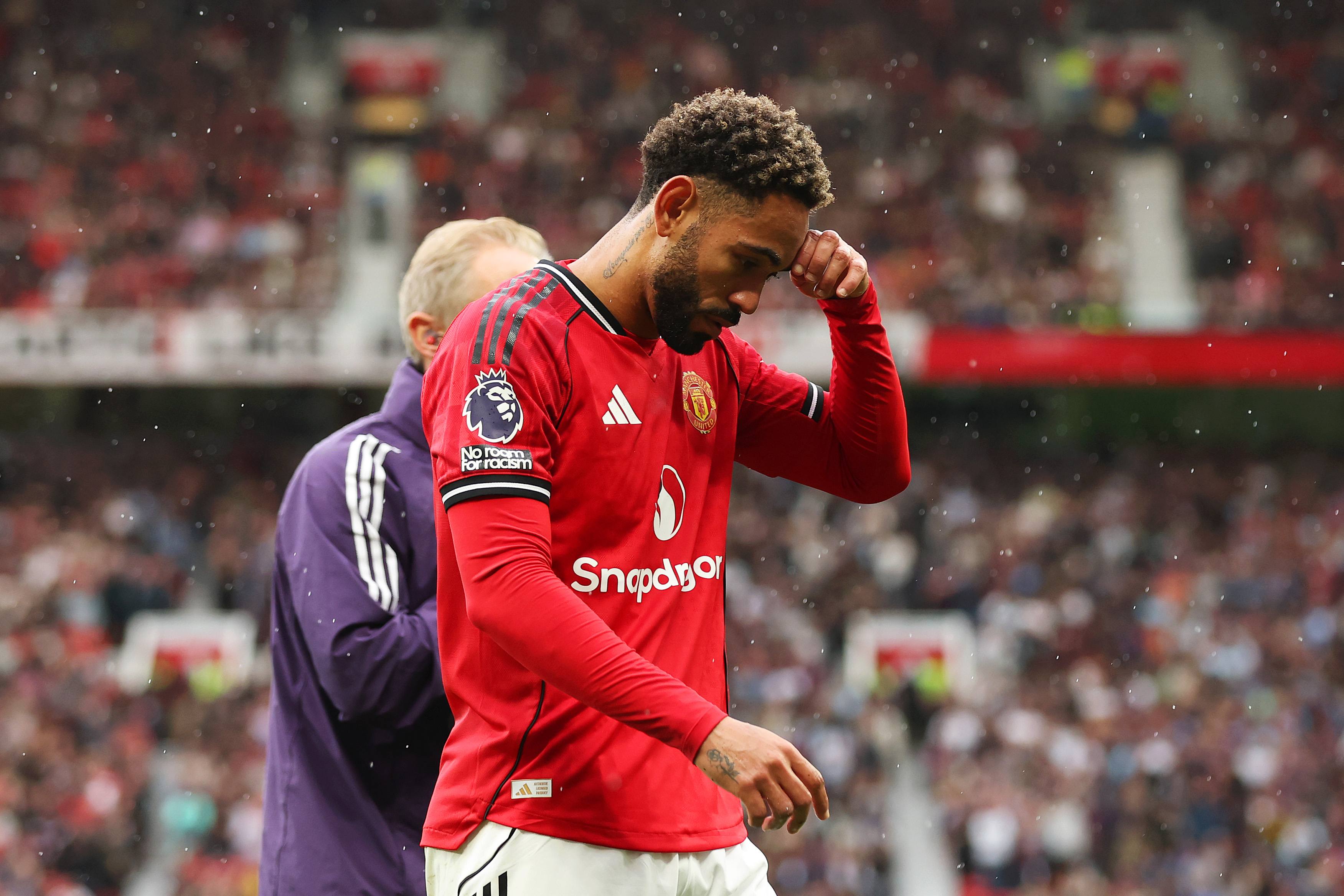 Matheus Cunha leaves the field after suffering an injury.