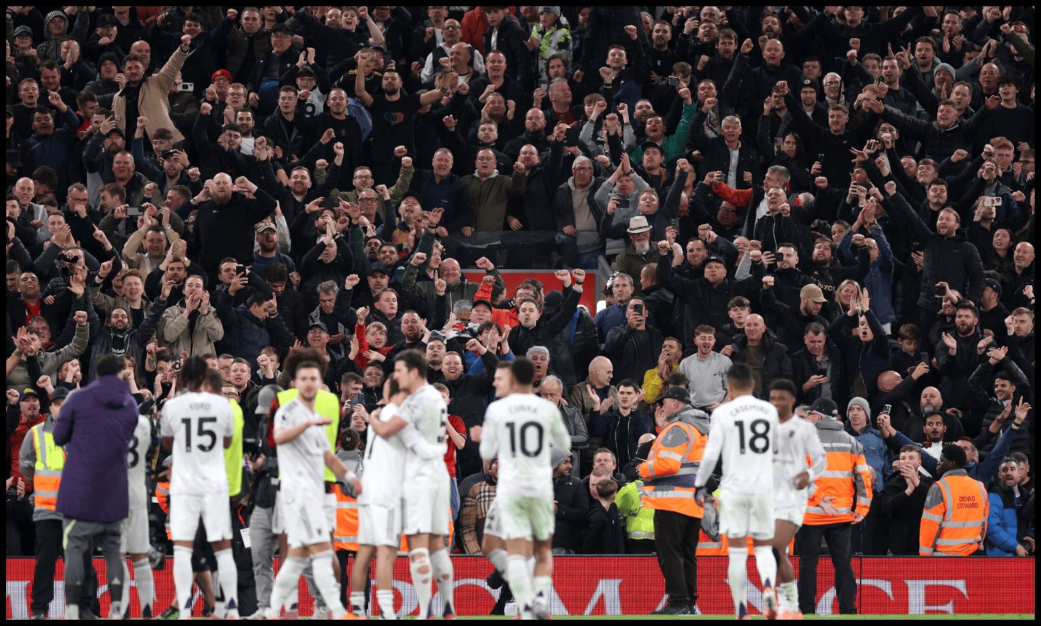 Manchester United players celebrate with their fans at Anfield.