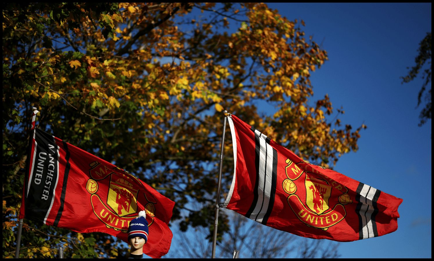 Man United flags fly outside Old Trafford.