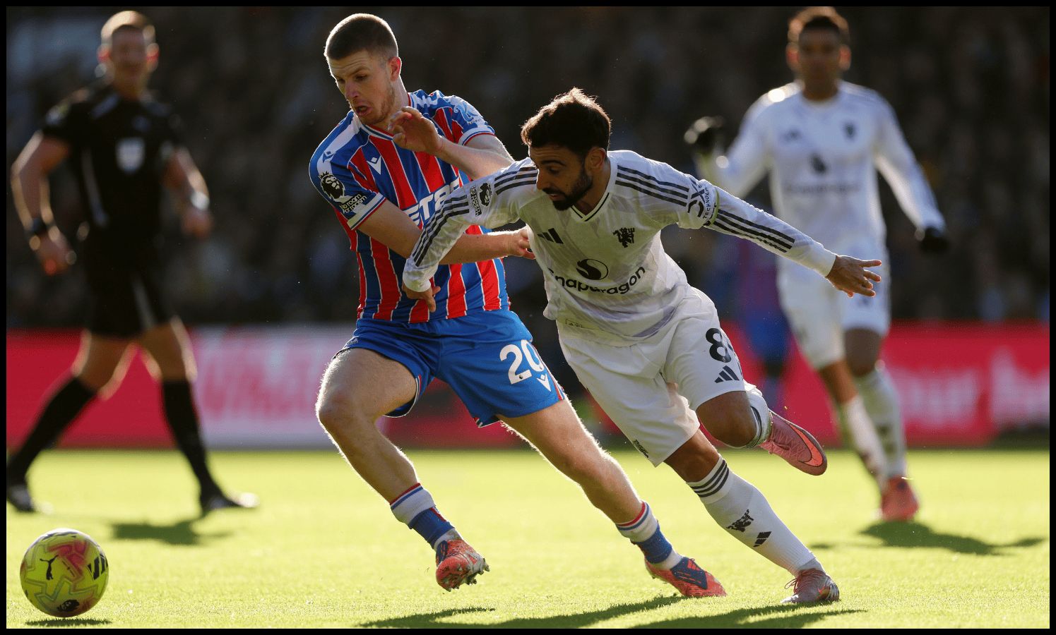 Bruno Fernandes vies for possession with Adam Wharton.
