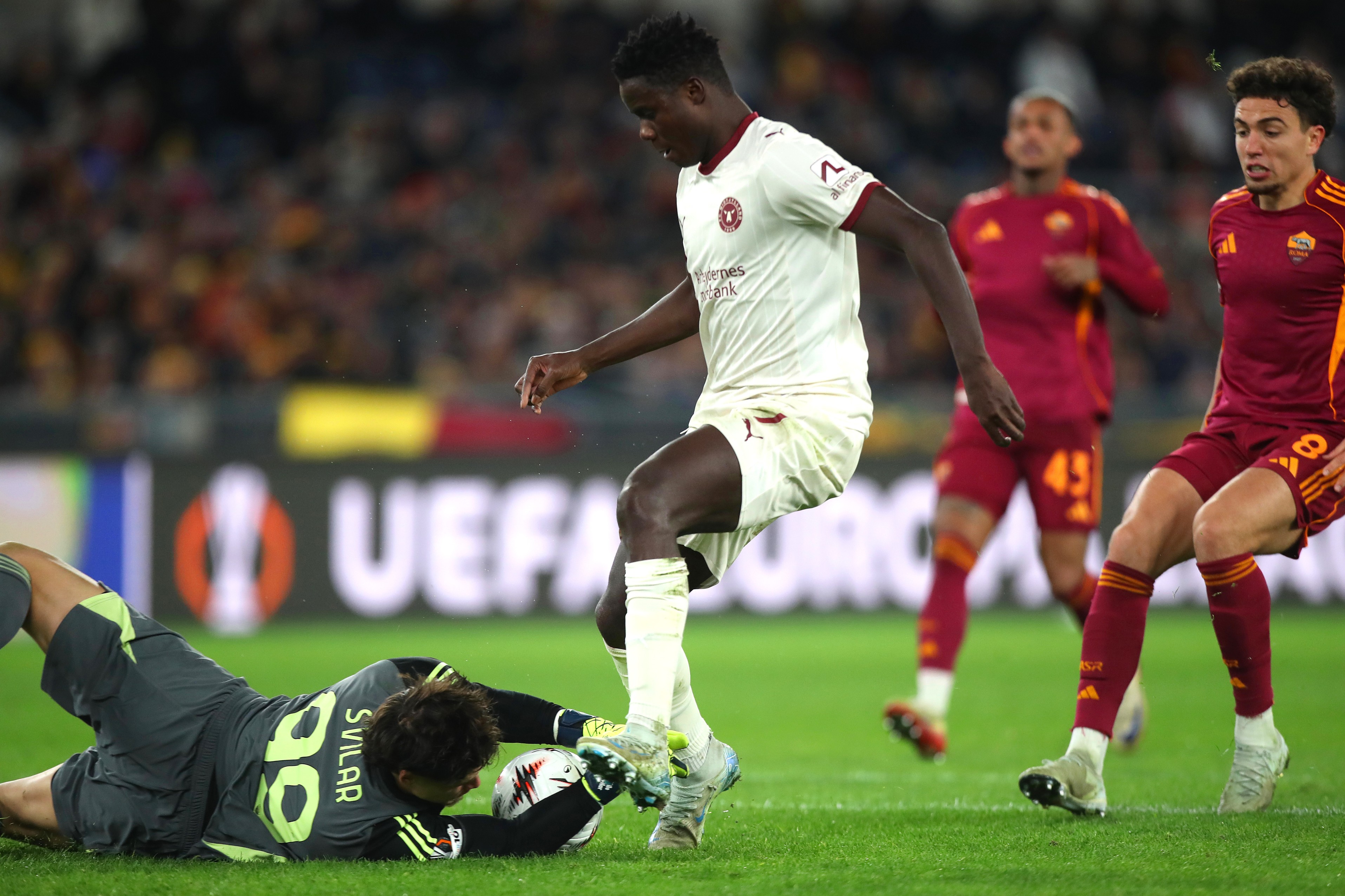Mile Svilar of AS Roma competes for the ball with Dju Franculino of FC Midtjylland