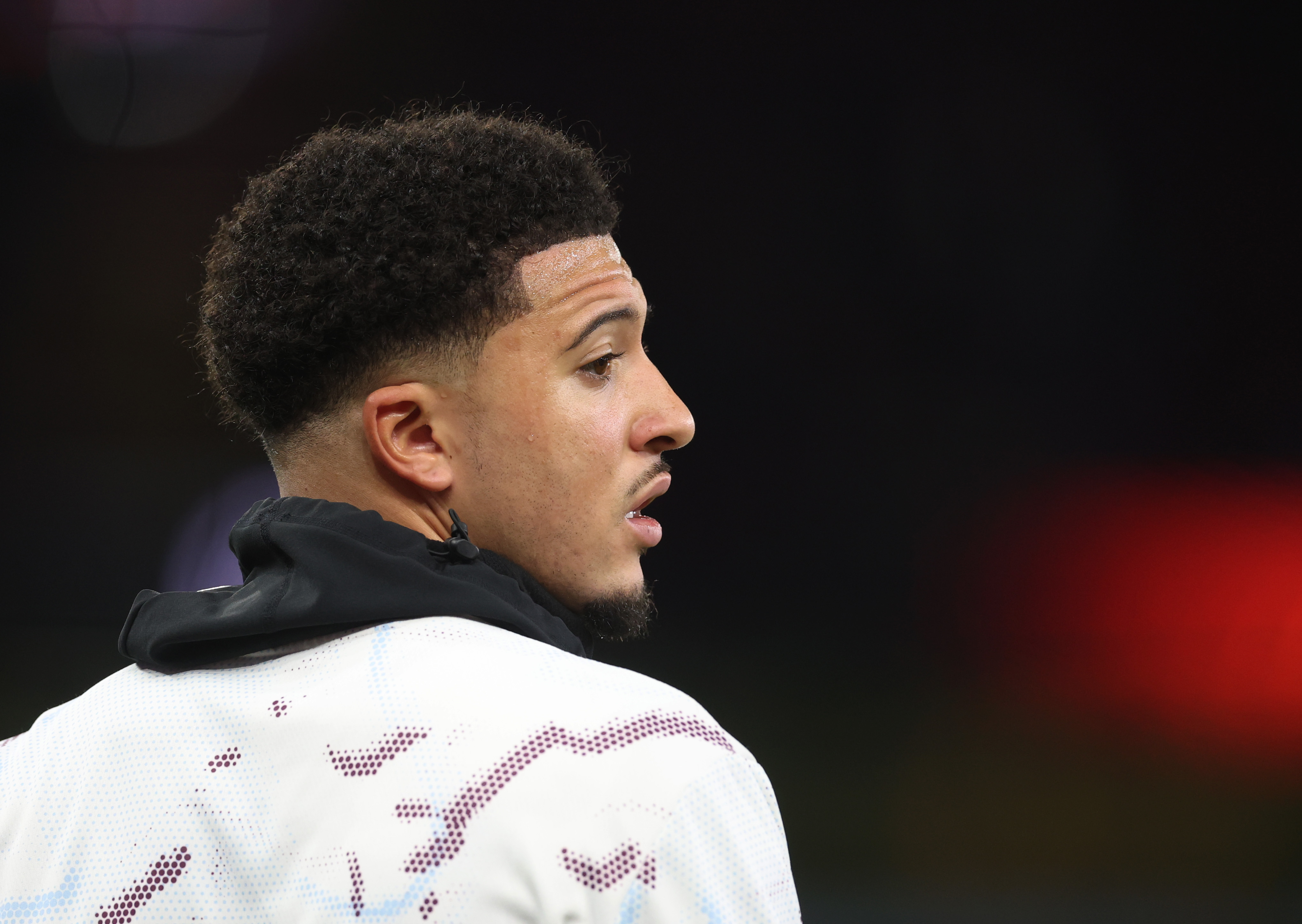 Jadon Sancho looks on while warming up for Aston Villa.