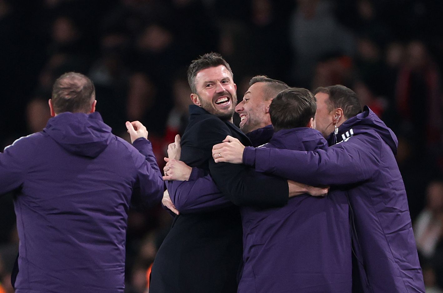 Michael Carrick hugs several members of Manchester United club staff.