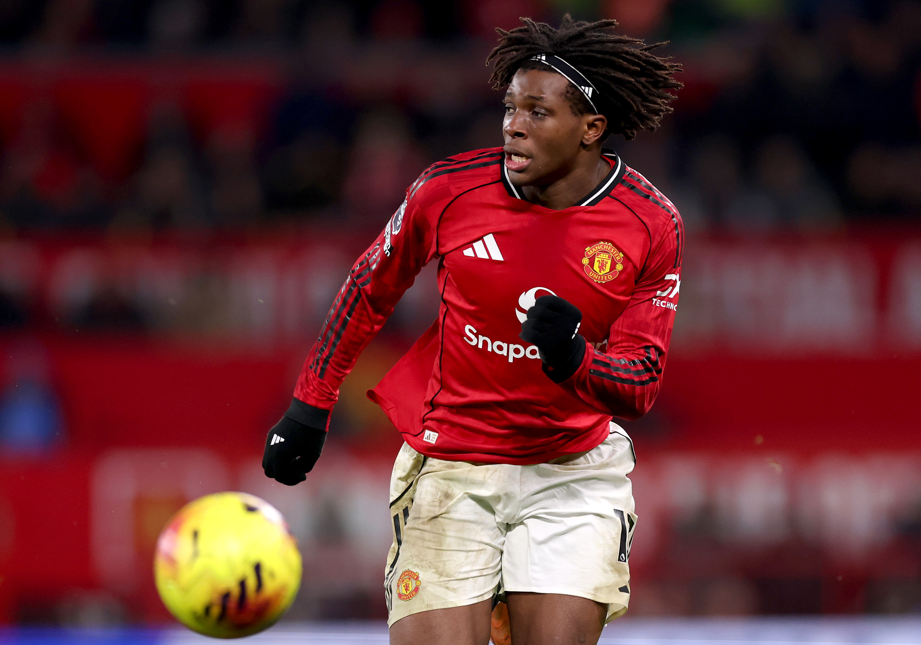 Patrick Dorgu runs with the ball while in action for Man United.