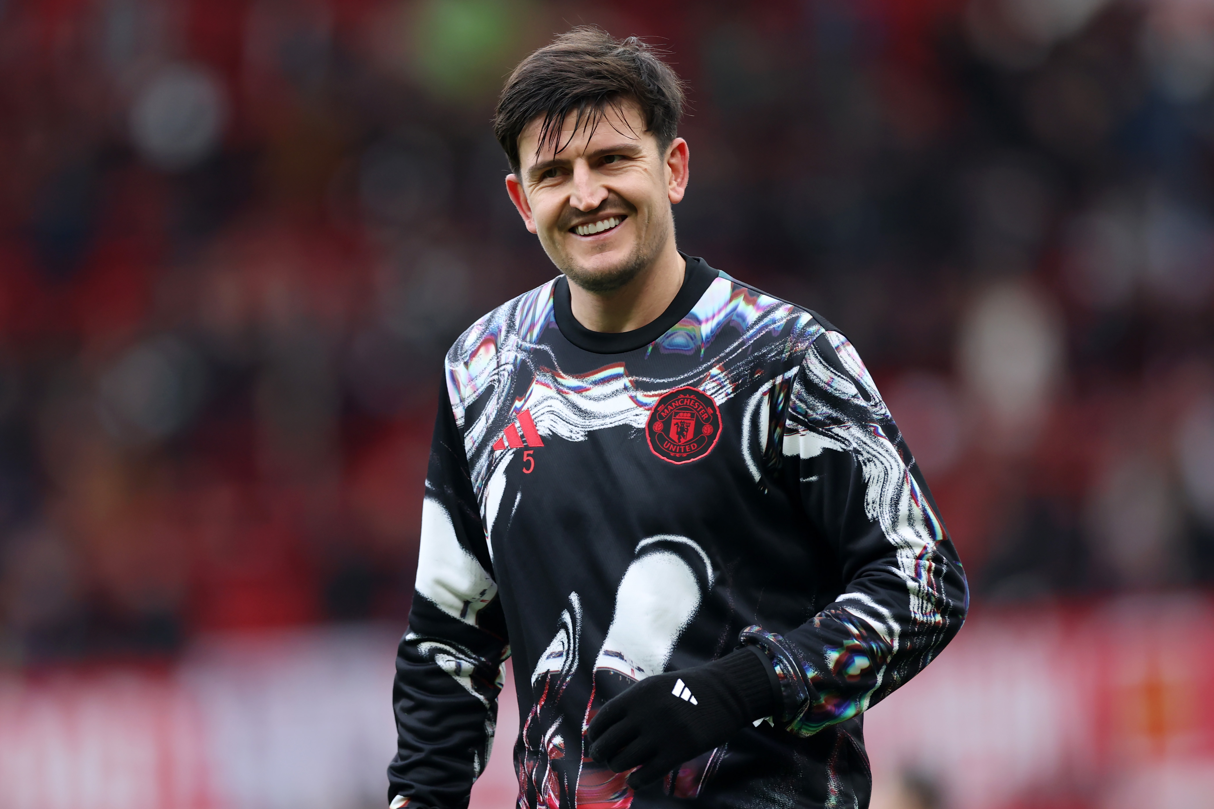 Harry Maguire smiles while warming up for Man United at Old Trafford before kick-off.