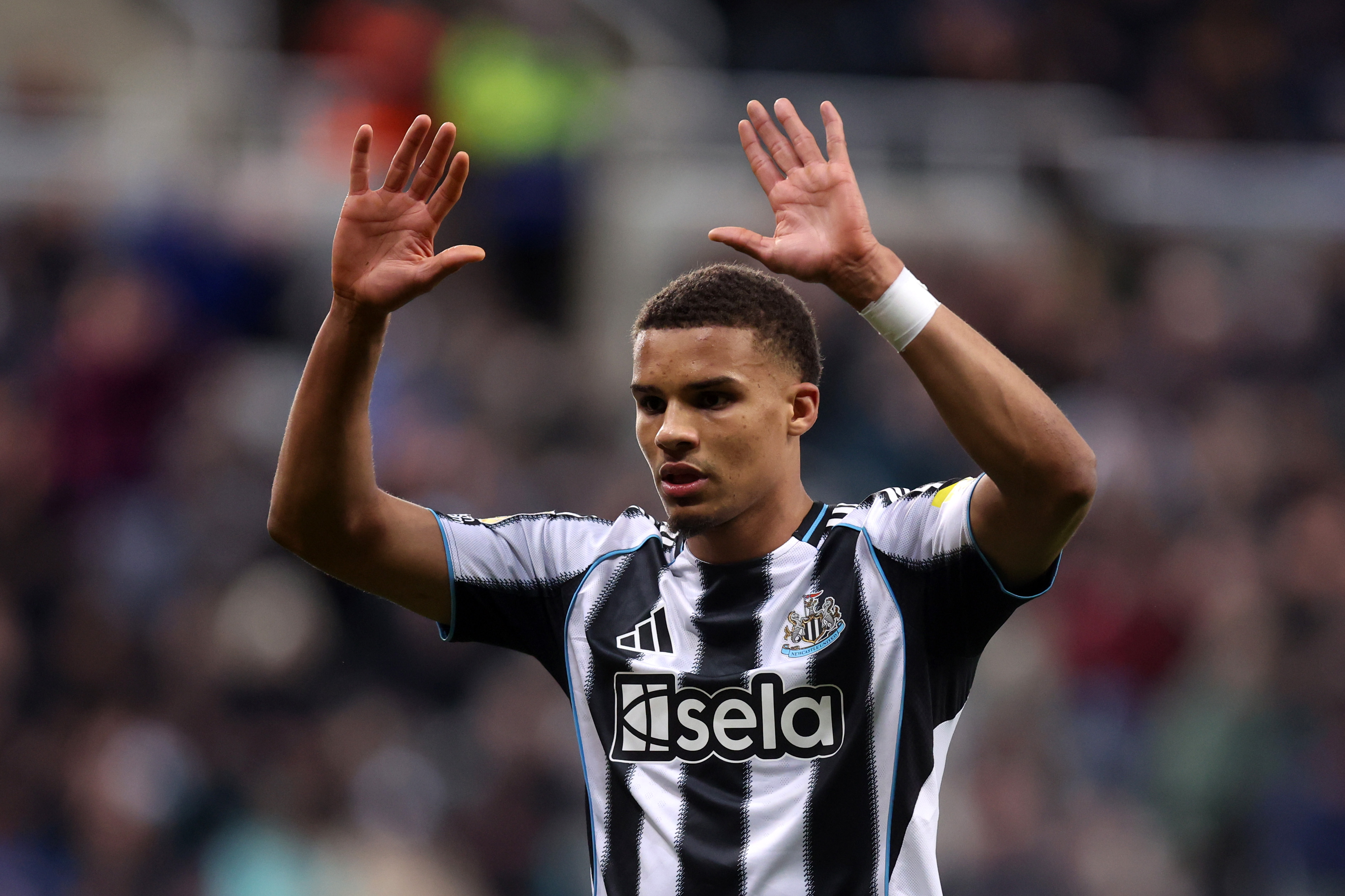 Malick Thiaw goes to embrace his teammate while in action for Newcastle.