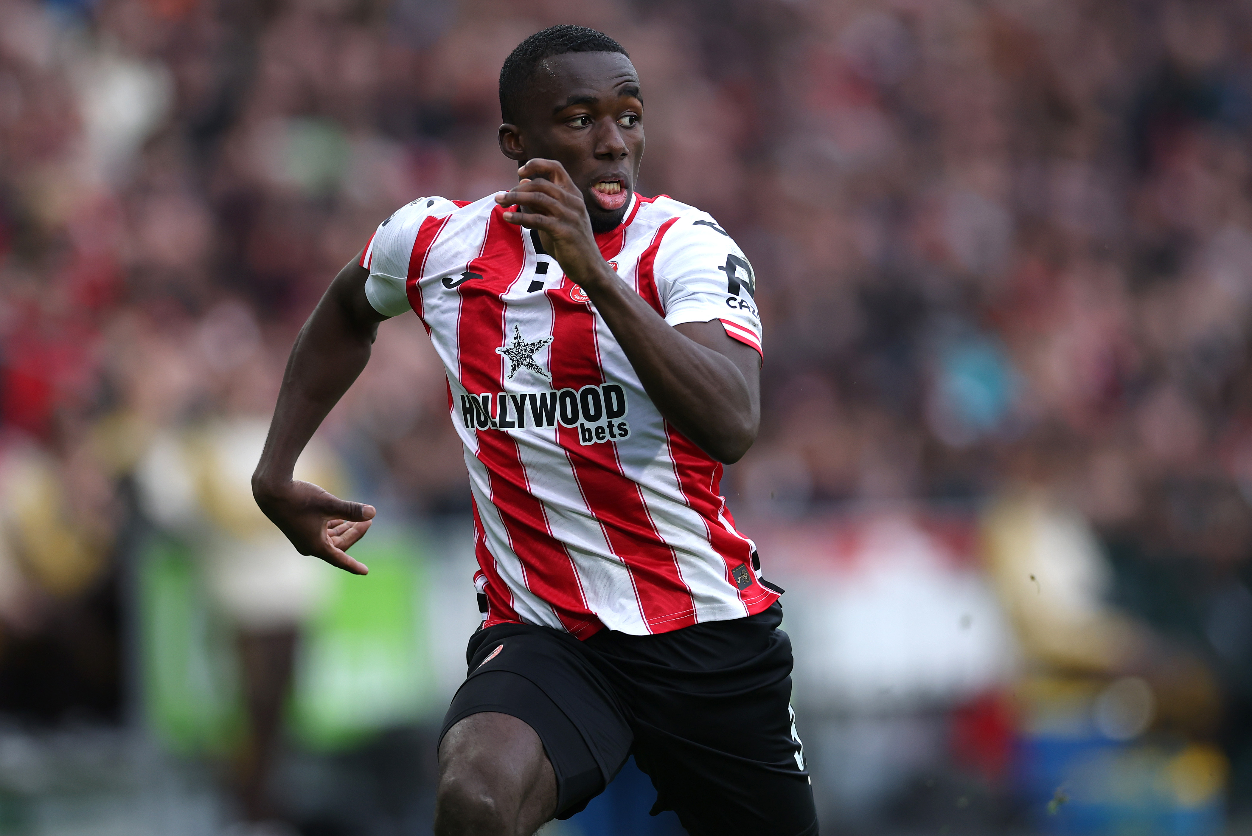 Michael Kayode of Brentford runs for the ball 