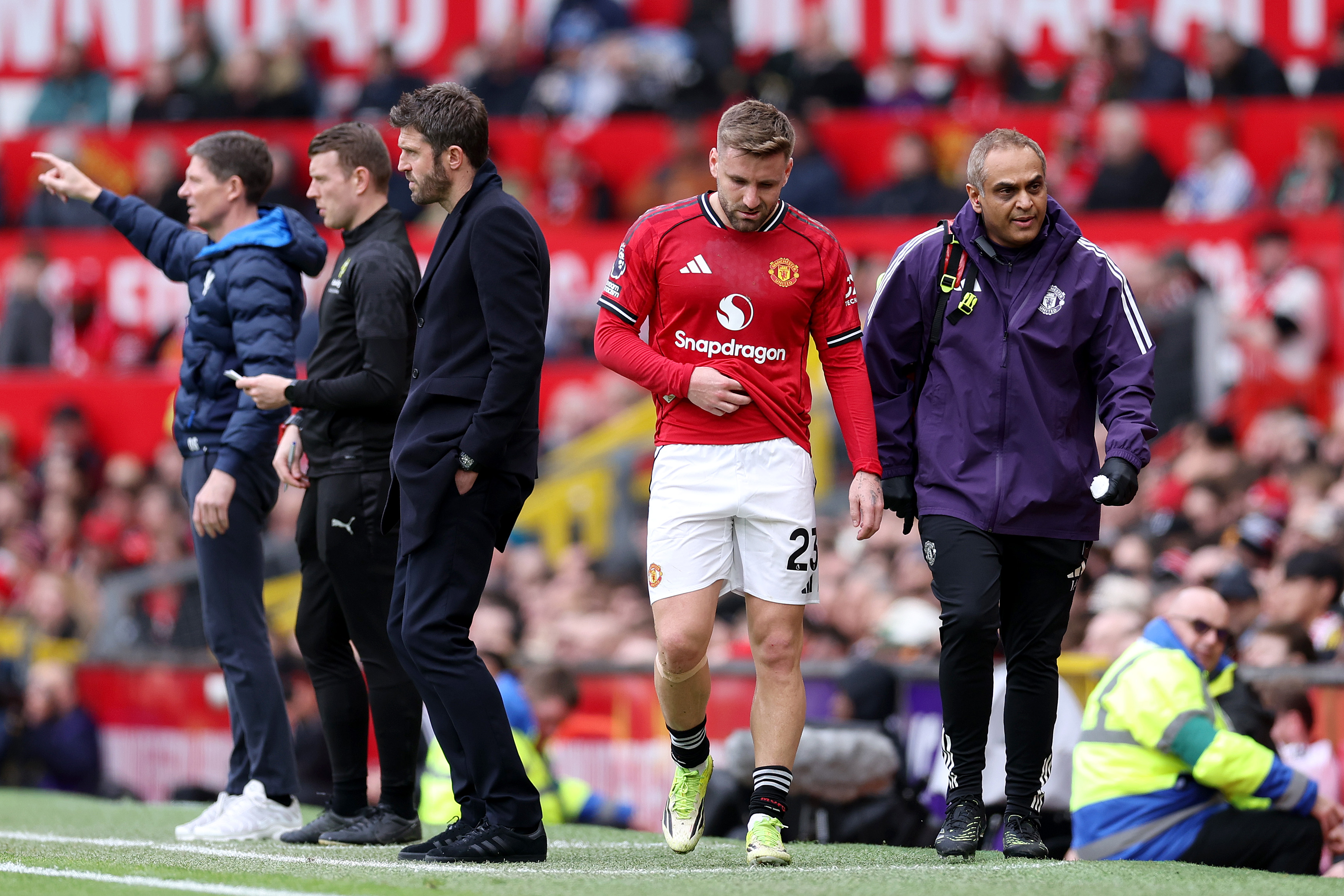 Luke Shaw leaves the pitch looking dejected after sustaining an injury.