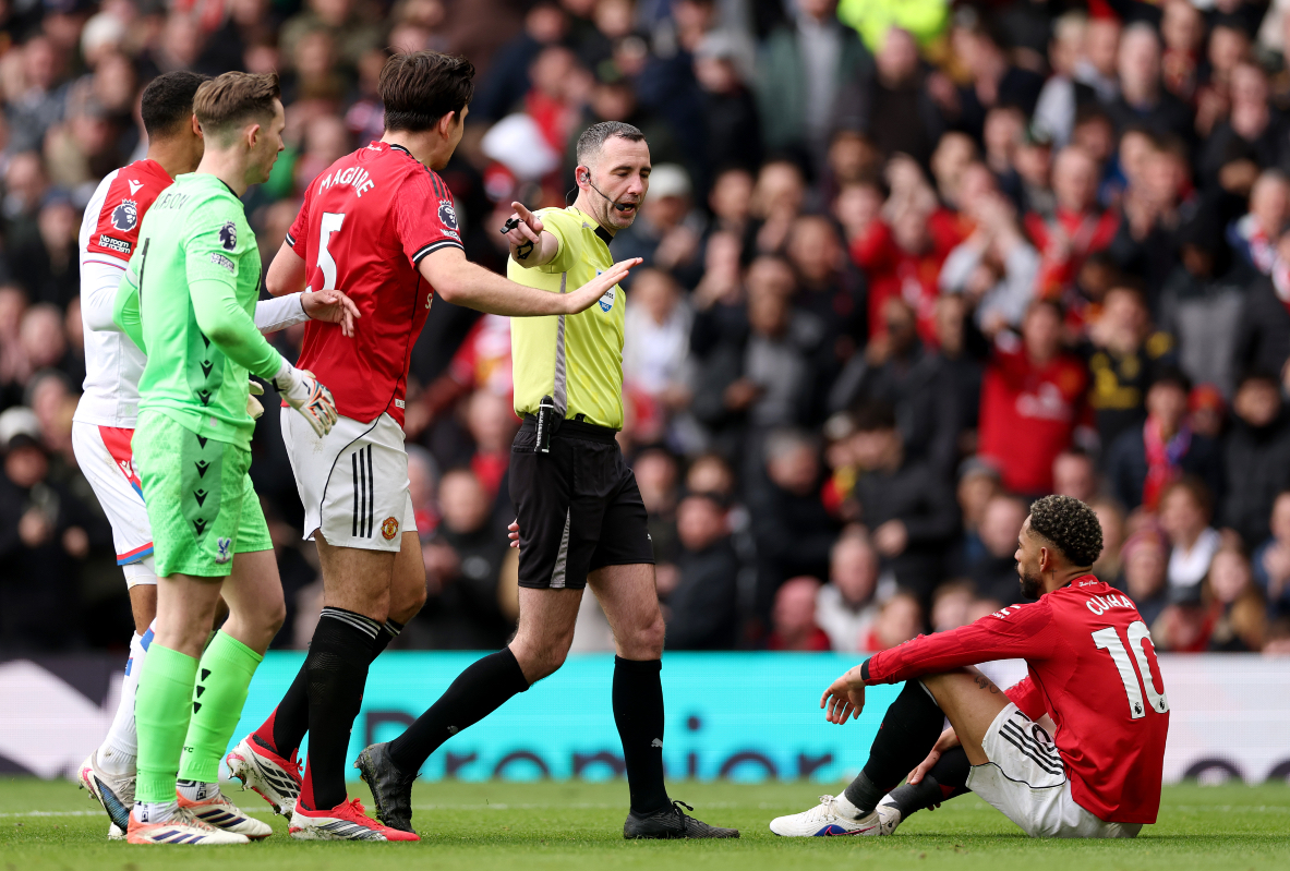 Referee Chris Kavanagh points to the penalty spot after Matheus Cunha is fouled inside the area.