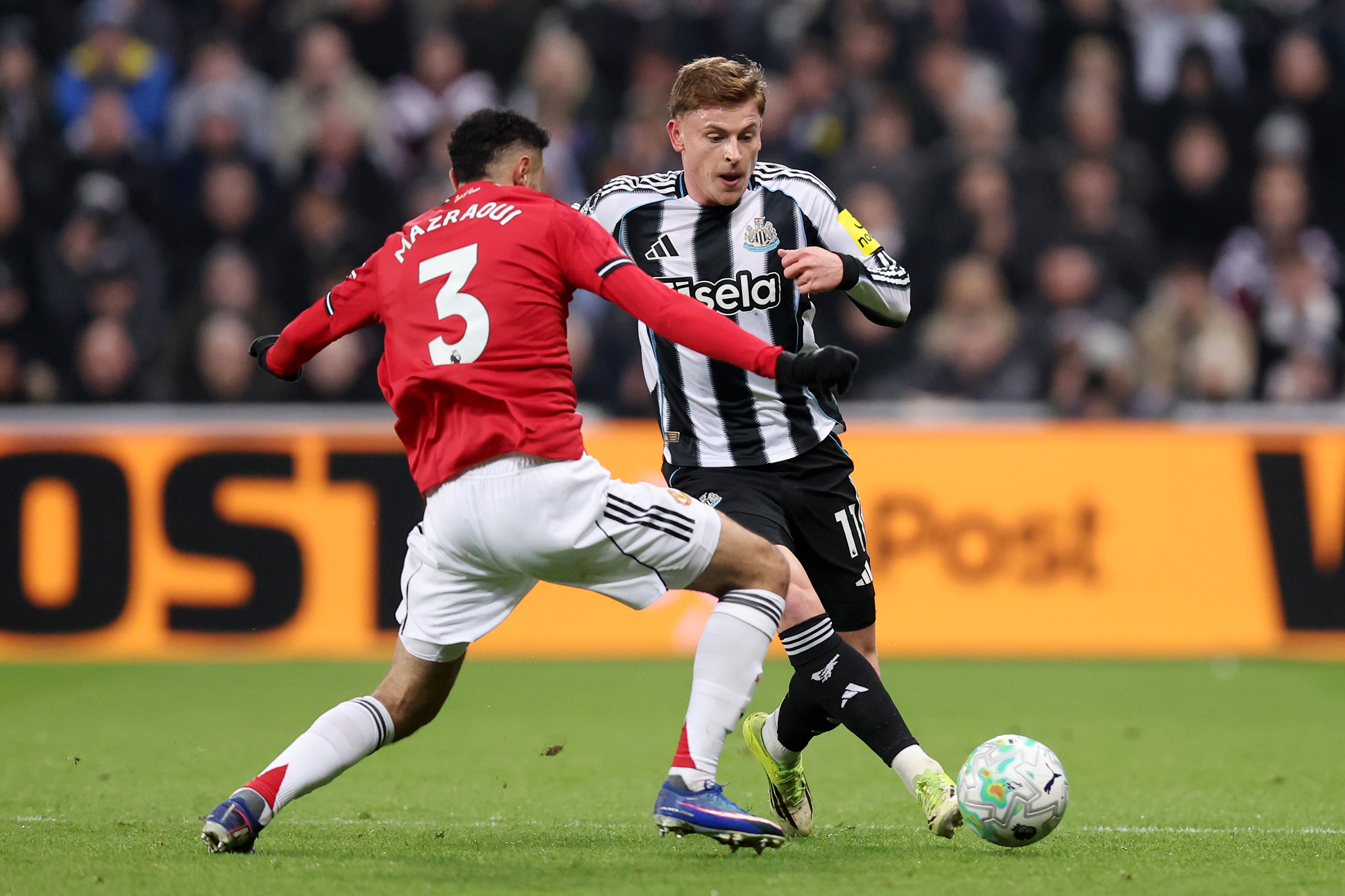 Noussair Mazraoui challenges Newcastle’s Harvey Barnes.
