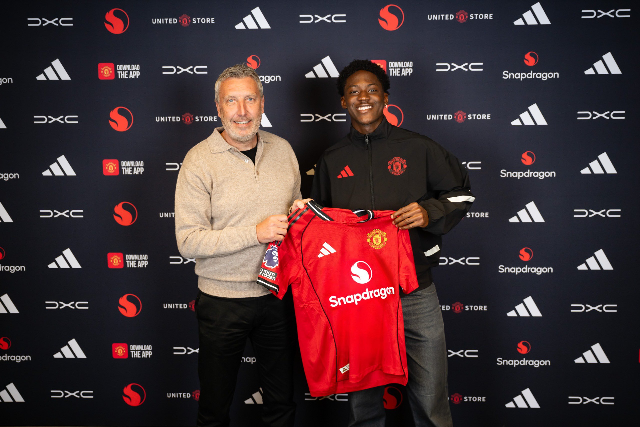 Jason Wilcox and Kobbi Mainoo pose with a Man United shirt after the latter’s contract announcement